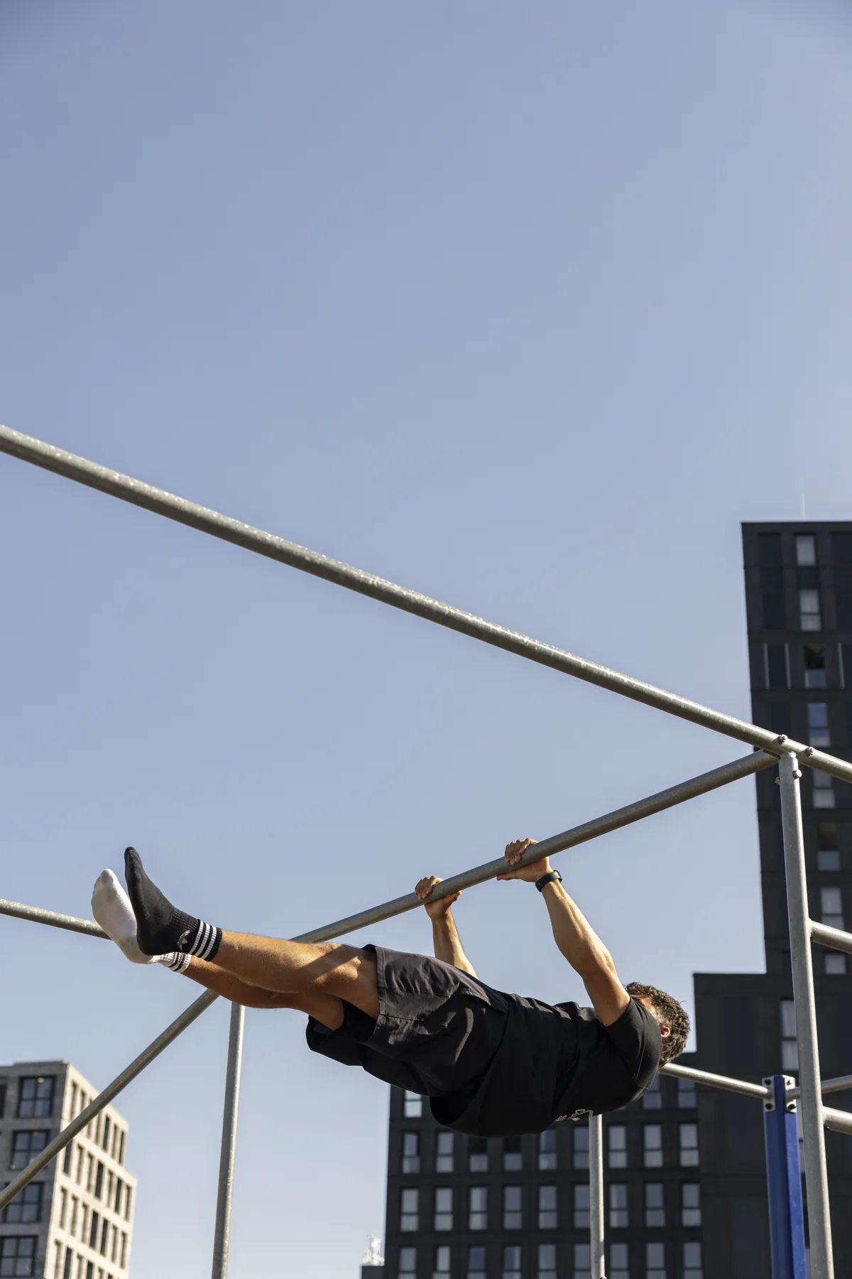 Bryan houdt een front lever aan de rekstok
